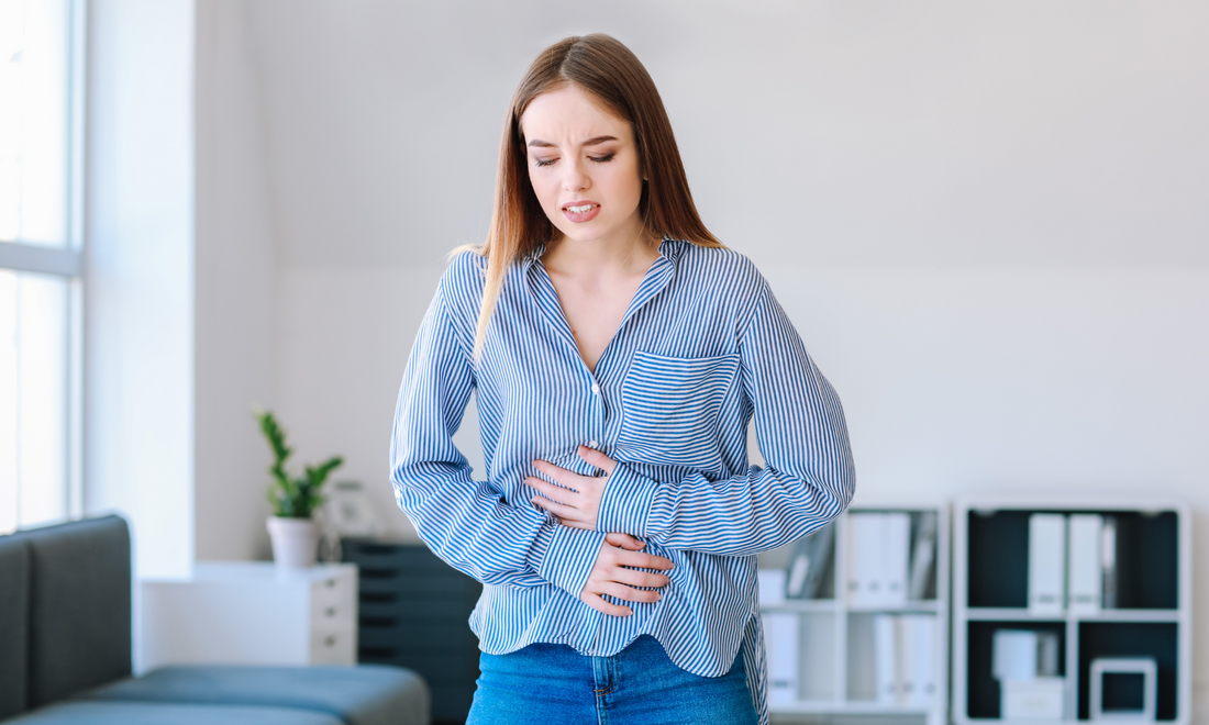 une femme habillé en bleu qui a mal au ventre